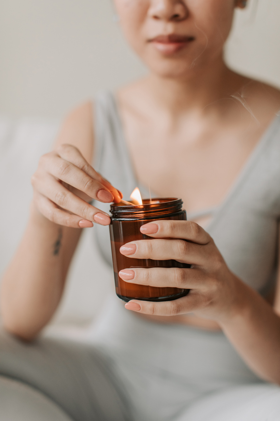 Woman Lighting a Candle in Jar